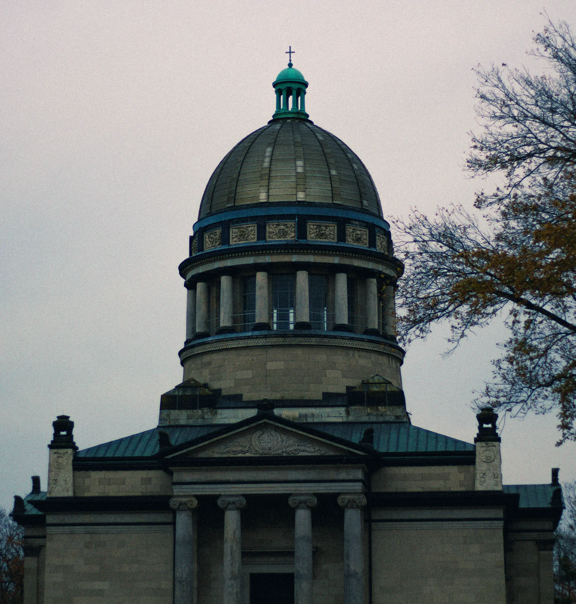 Full view of neoclassical domed mausoleum with autumn trees and overcast lavender sky, Dessau venue of FEAST & ROADKILL exhibition 2025